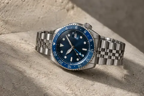 Montre GMT Seiko à boîtier rond argenté, accents bleus, verre Hardlex et bracelet assorti